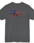 Asphalt color fabric patriotic shirt rear view has an americantees.us logo with eagle head on front , rear view has distressed American flag with modern sporting rifle with the log Pro Armis Libertas meaning For Arms, Freedom