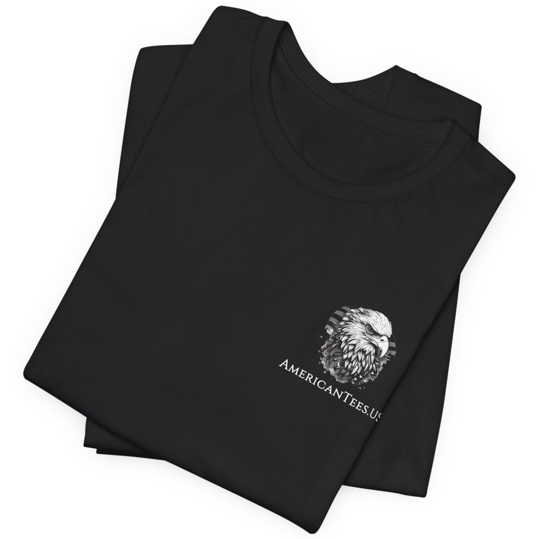 front view of a folded black colored fabric patriotic shirt with americantees.us logo on front and American flag in shape of a Christian cross with pledge of allegiance surrounding image on back