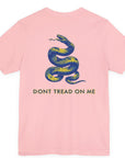 rear view of a pink colored fabric shirt with americantees.us logo on front and a Gadsden flag on the back
