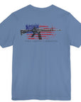Lavender blue color fabric patriotic shirt rear view has an americantees.us logo with eagle head on front , rear view has distressed American flag with modern sporting rifle with the log Pro Armis Libertas meaning For Arms, Freedom