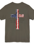 rear view of an army green colored fabric patriotic shirt with americantees.us logo on front and American flag in shape of a Christian cross with pledge of allegiance surrounding image on back