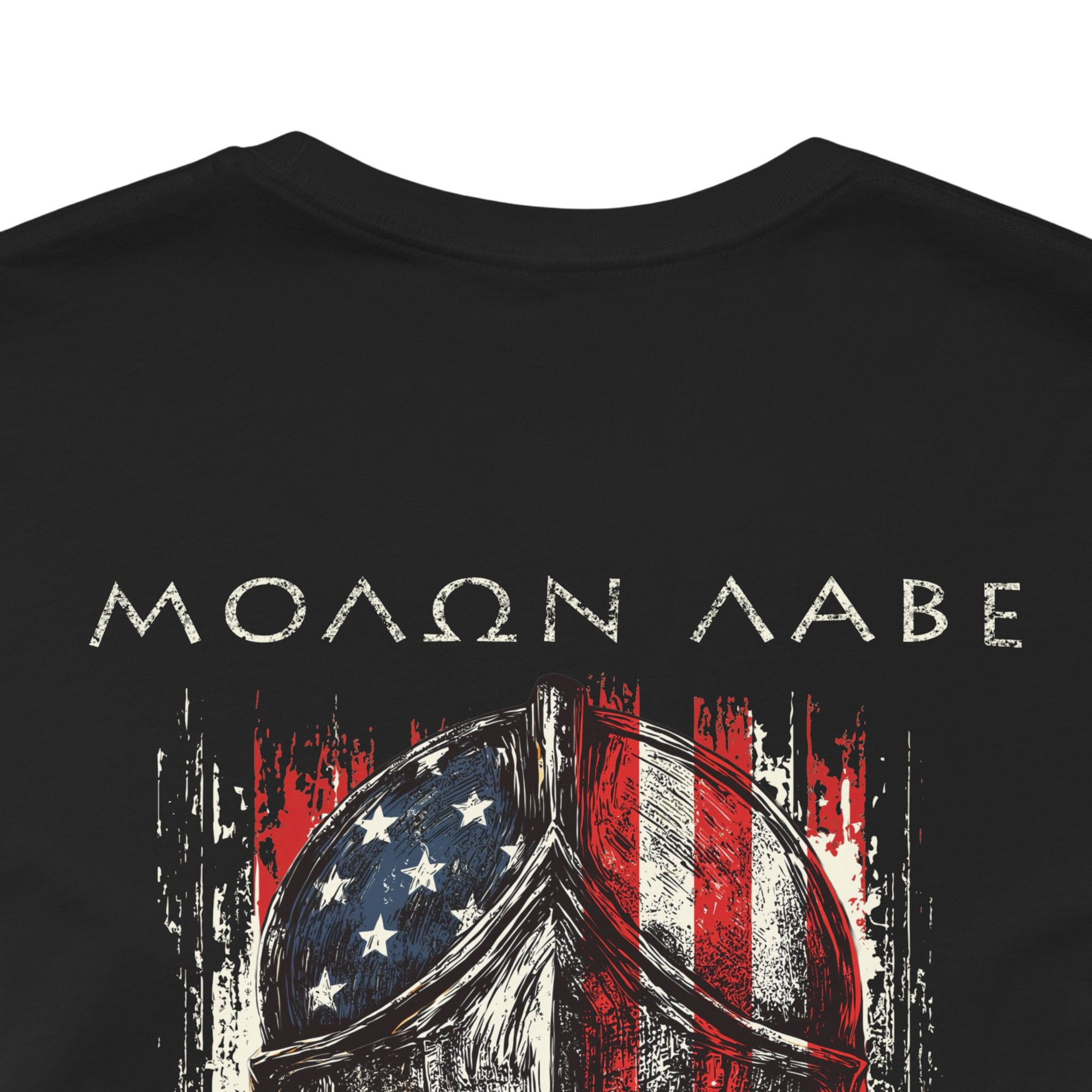 front view close-up black color fabric tee with americantees.us logo on front with spartan helmet covered with american flag and motto molon labe patriotic shirt