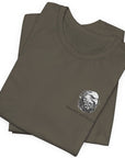 Army green color fabric folded patriotic shirt front view has an americantees.us logo with eagle head , rear view has distressed American flag with modern sporting rifle with the log Pro Armis Libertas meaning For Arms, Freedom