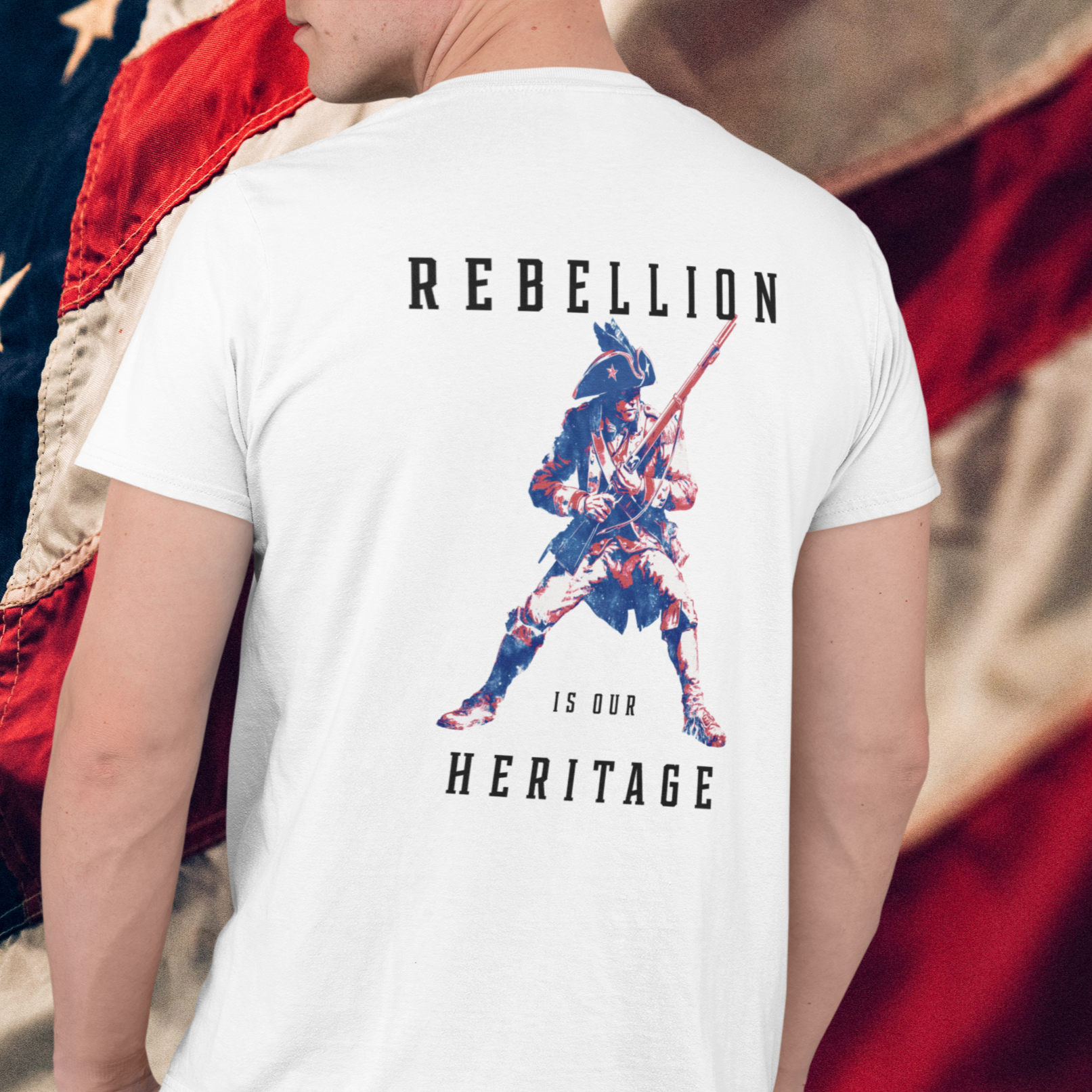 man wearing a patriotic shirt rearview white color fabric logo on front graphic on back with minuteman soldier and phrase rebellion is our heritage, American t-shirt