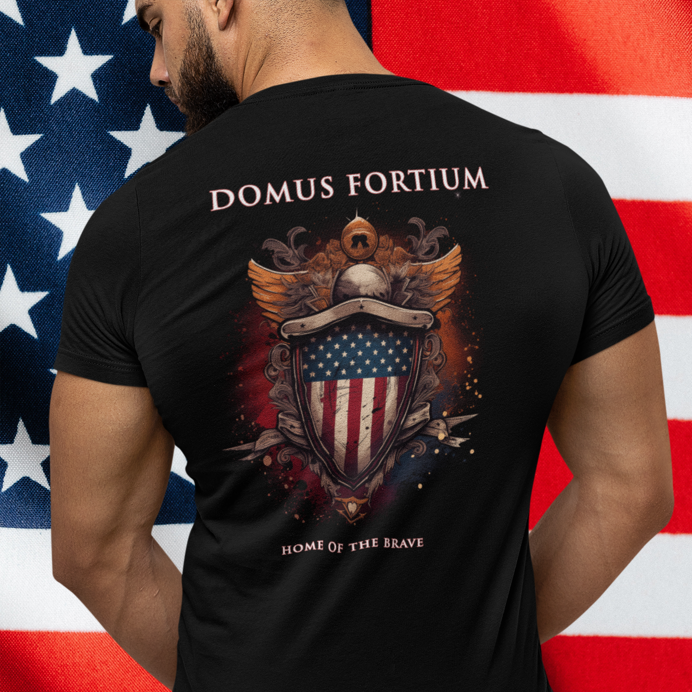 man standing in front of a flag wearing a patriotic shirt front view black color fabric tee logo with eagle on front, american flag on shield with scrollwork, Domus Fortium, home of the brave motto