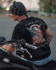 rear view of a man on a motorcycle wearing a patriotic shirt white color fabric tee with logo on front and american flag with liberty bell and crossed rifles on back, motto that states Come and Take Them and molon labe on scroll