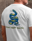 rear view of a man wearing a white colored fabric shirt with americantees.us logo on front and a Gadsden flag on the back