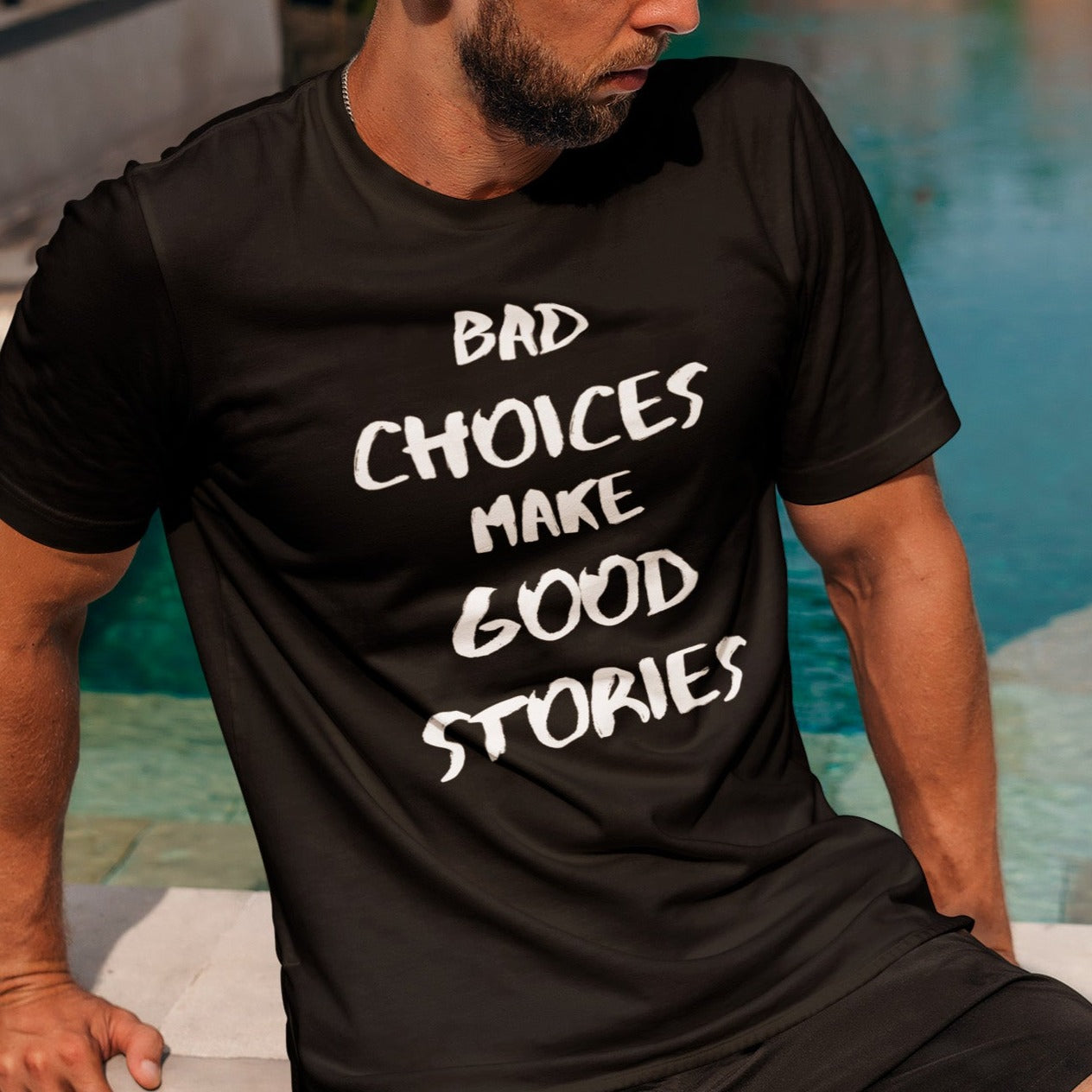 bad-choices-make-good-stories-black-t-shirt-funny-unisex-mockup-of-a-bearded-man-with-a-t-shirt-sitting-by-a-pool