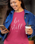 be-still-psalm-46-10-berry-t-shirt-womens-christian-inspiring-bella-canvas-tee-mockup-of-a-woman-checking-her-phone-while-drinking-coffee-on-the-street