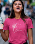 believe-with-dandelion-wishes-berry-t-shirt-womens-inspiring-tee-mockup-of-a-joyful-woman-holding-a-glass-of-water