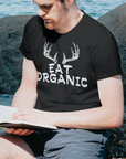 eat-organic-blackt-shirt-mockup-of-a-man-reading-a-bible-by-the-beach