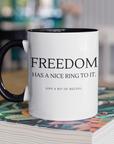 freedom-has-a-nice-ring-to-it-and-a-bit-of-recoil-glossy-mug-11-oz-2a-mockup-of-a-two-toned-coffee-mug-mockup-on-a-table