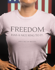 freedom-has-a-nice-ring-to-it-and-a-bit-of-recoil-pink-t-shirt-2a-mockup-of-a-woman-veteran-standing-against-an-american-flag