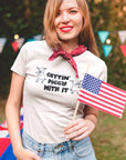 gettin-piggy-with-it-white-t-shirt-funny-dancing-pigs-smiling-patriot-girl-wearing-a-t-shirt-mockup-at-a-4th-of-july-bbq-party