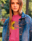 in-a-world-full-of-roses-be-a-sunflower-berry-t-shirt-womens-mockup-of-a-woman-posing-at-a-park