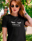 lashes-so-long-i-cant-see-my-haters-black-t-shirt-womens-mockup-of-a-woman-under-the-shadow-of-a-floral-tree