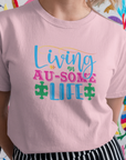 living-an-au-some-life-autism-awareness-month-pink-t-shirt-mockup-of-a-pretty-woman-smiling-in-front-of-a-colorful-background