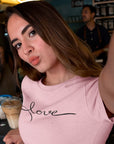 love-pink-t-shirt-womens-woman-taking-a-selfie-while-at-a-coffee-counter-bar-wearing-a-tee