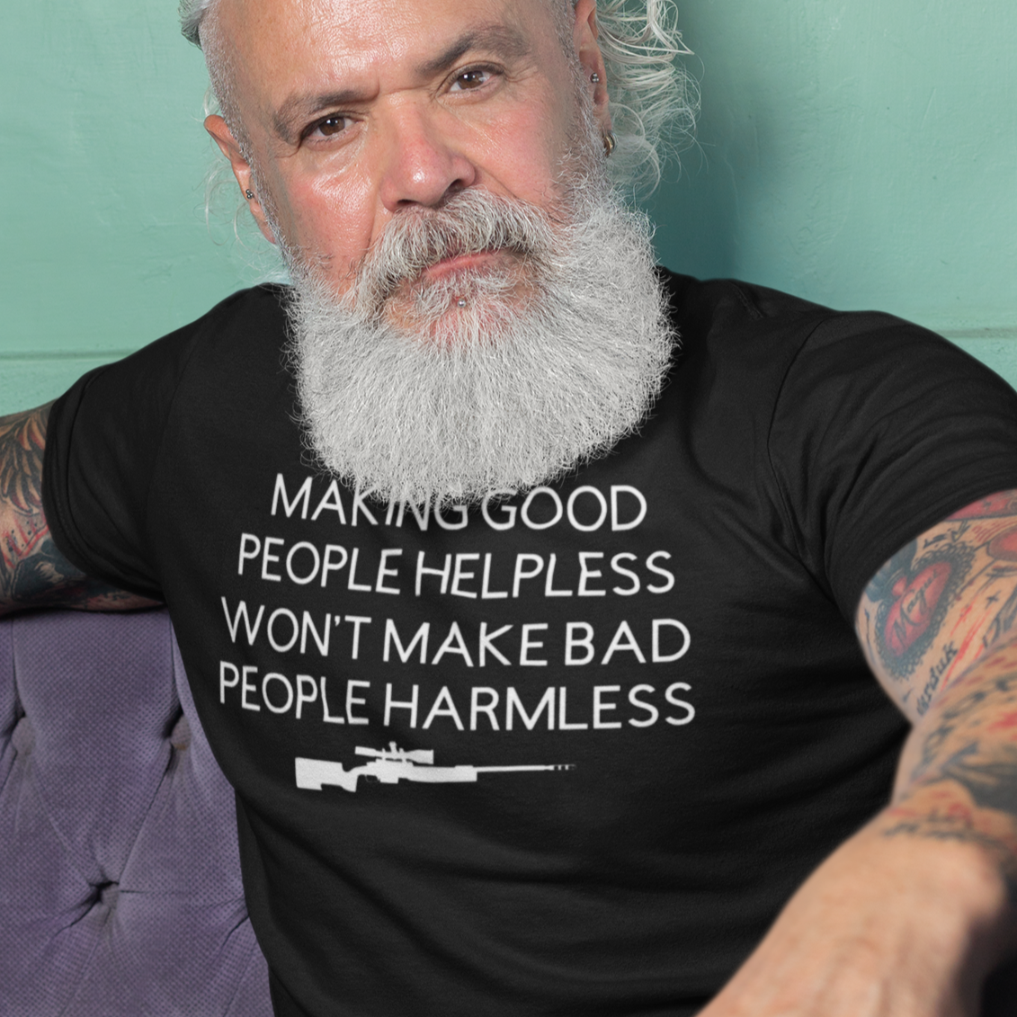 making-good-people-helpless-wont-make-bad-people-harmless-black-t-shirt-mockup-featuring-a-man-sitting-on-a-purple-sofa