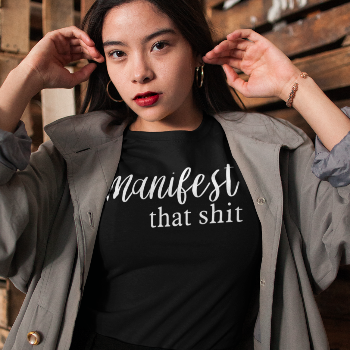 manifest-that-shit-black-t-shirt-womens-tee-mockup-of-a-woman-surrounded-by-wooden-crates
