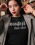 manifest-that-shit-black-t-shirt-womens-tee-mockup-of-a-woman-surrounded-by-wooden-crates
