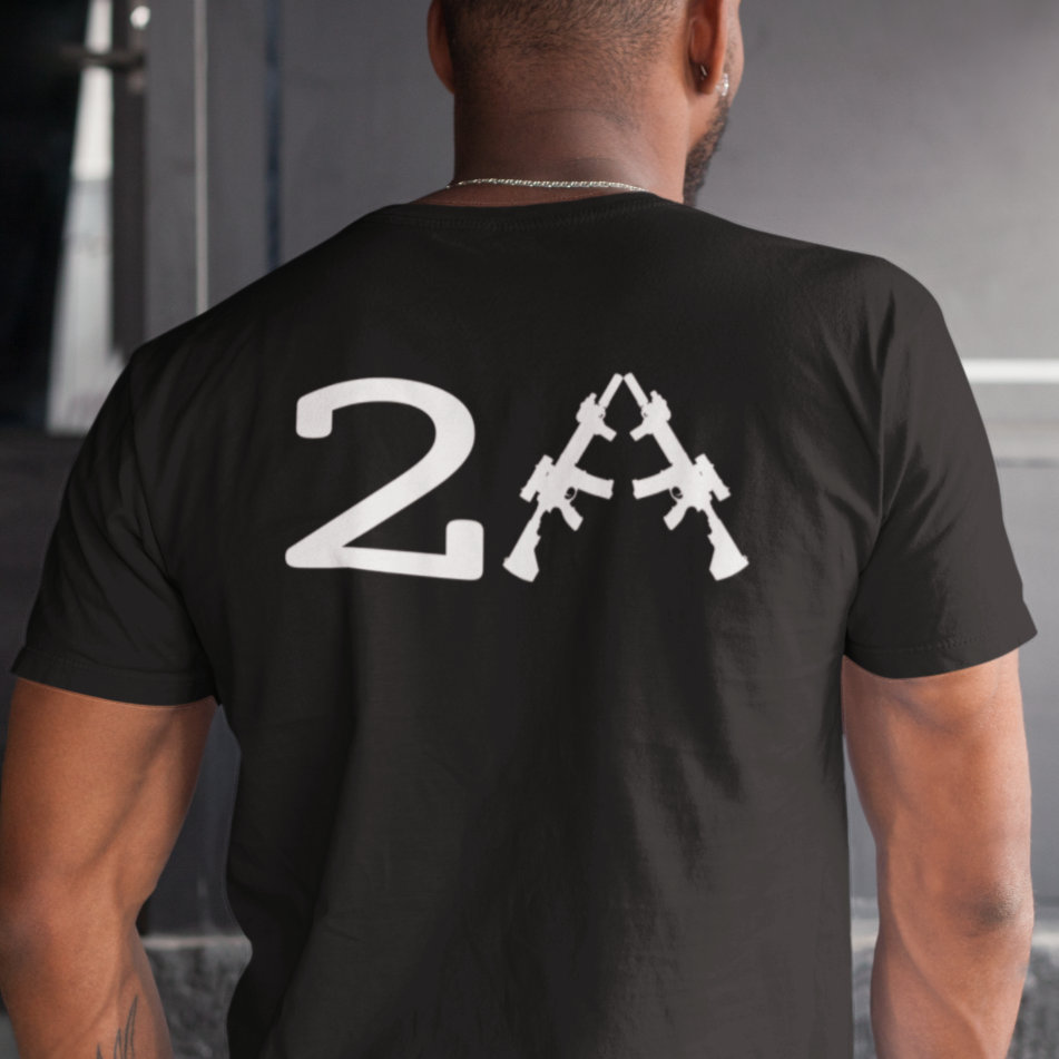 man standing in a house wearing a patriotic black colored fabric shirt with americantees.us logo on front and 2A on the back with stacked rifles forming the A