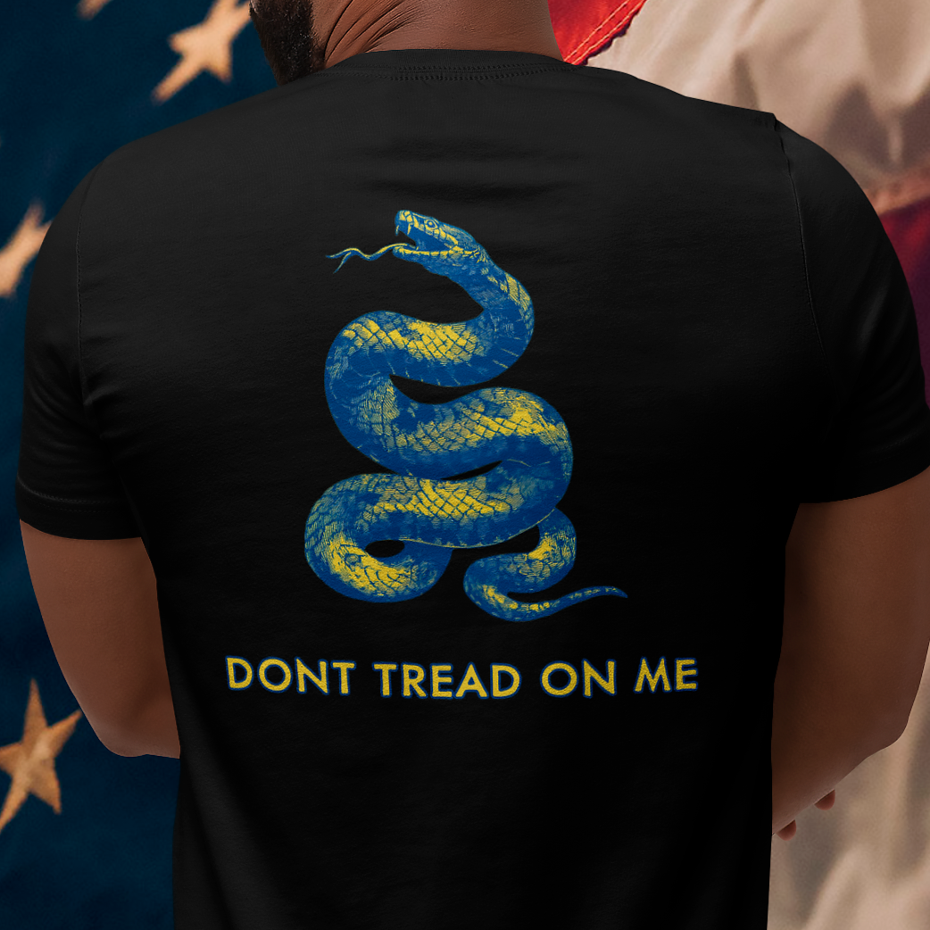 rear view of a man wearing a black colored fabric shirt with americantees.us logo on front and a Gadsden flag on the back