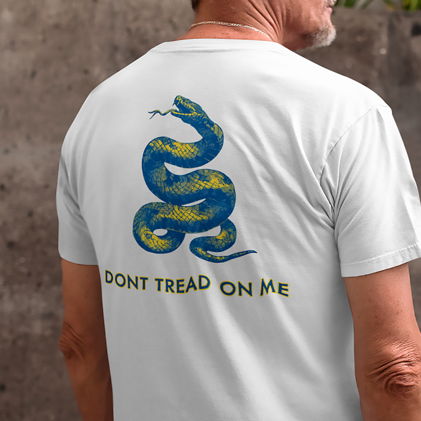 rear view of a man wearing a white colored fabric shirt with americantees.us logo on front and a Gadsden flag on the back