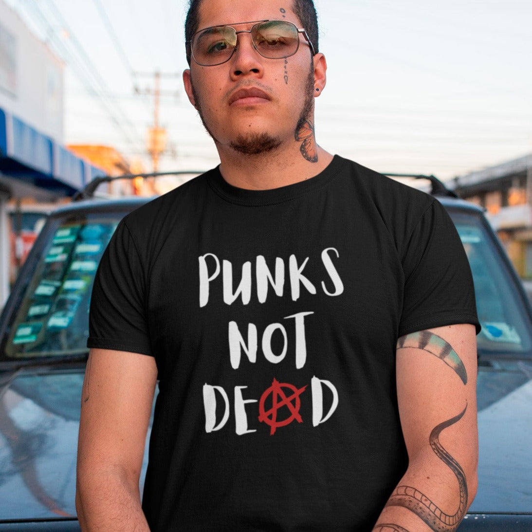 punks-not-dead-anarchy-sign-black-t-shirt-mockup-of-a-tattooed-man-posing-on-the-street
