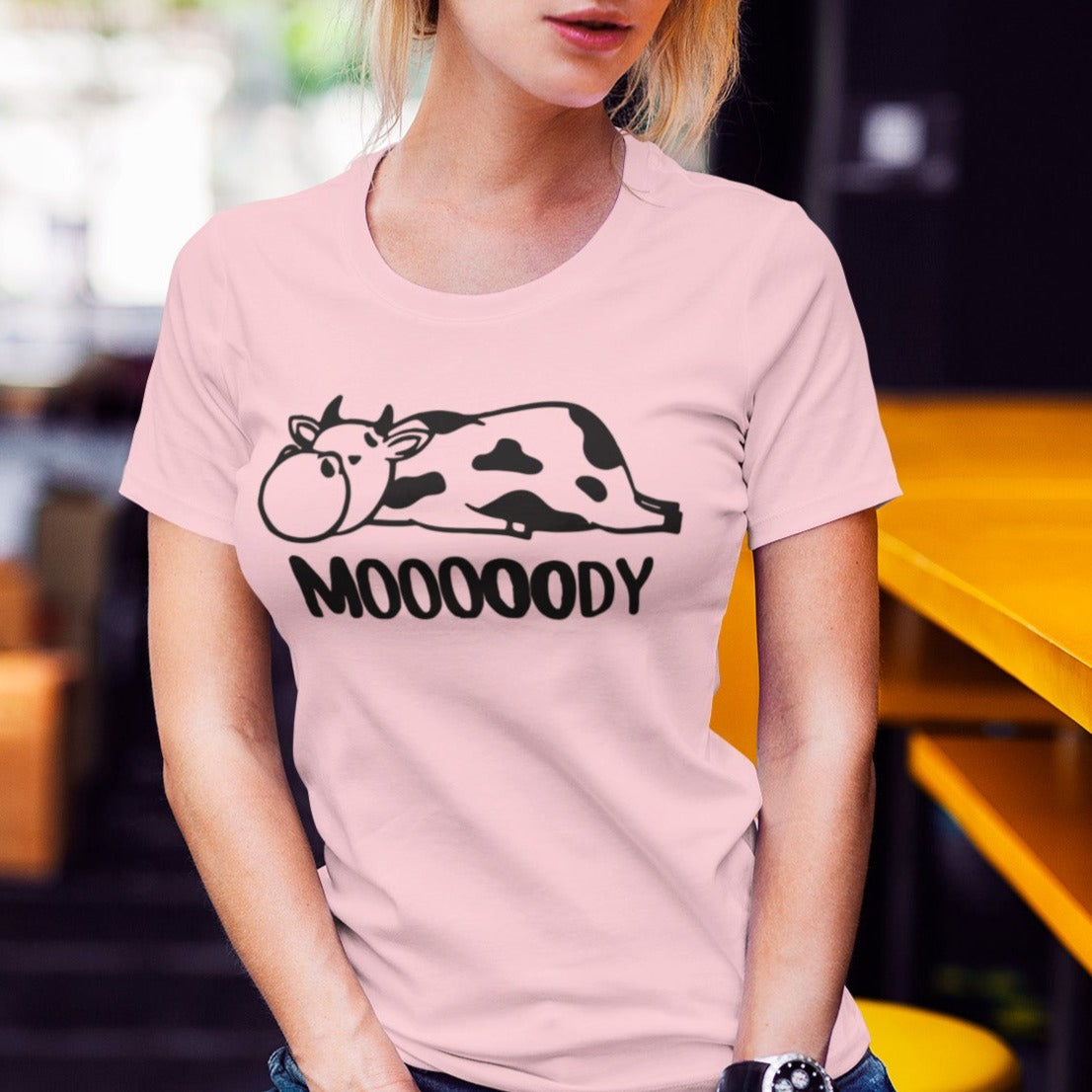 Mooooody-cow-farm-pink-t-shirt-funny-cropped-face-t-shirt-mockup-featuring-a-woman-sitting-on-a-stool