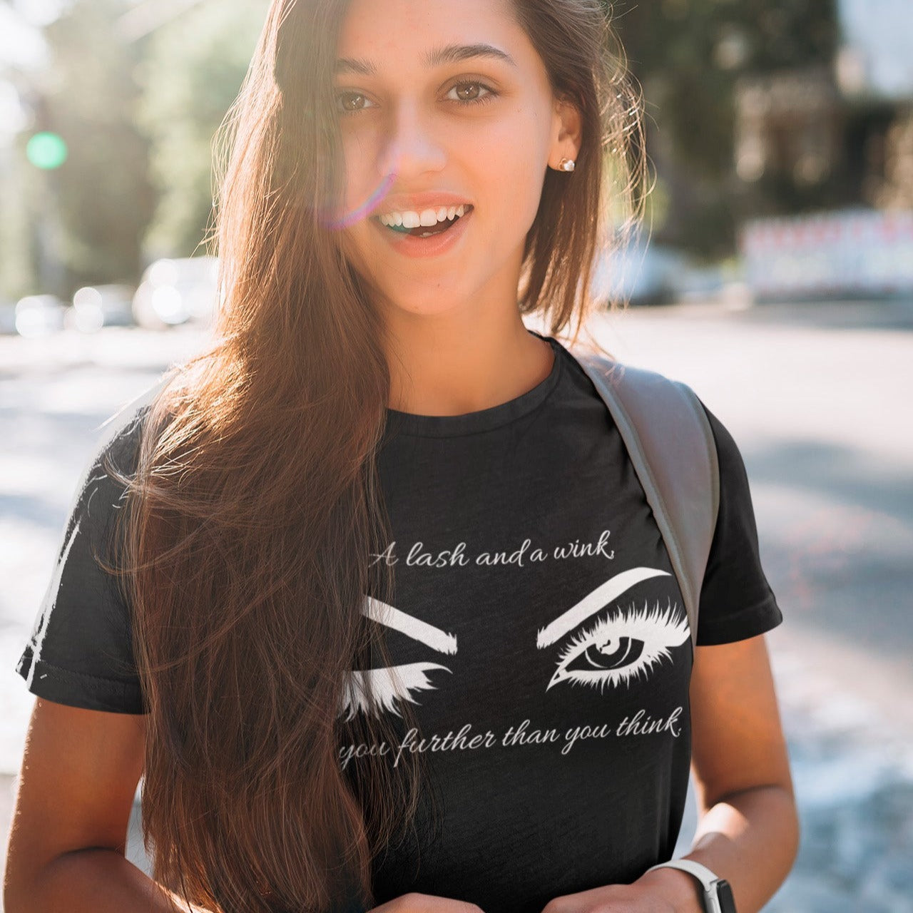 a-lash-and-a-wink-gets-you-further-than-you-think-black-t-shirt-womens-lashes-mockup-featuring-a-college-student-on-a-sunny-day