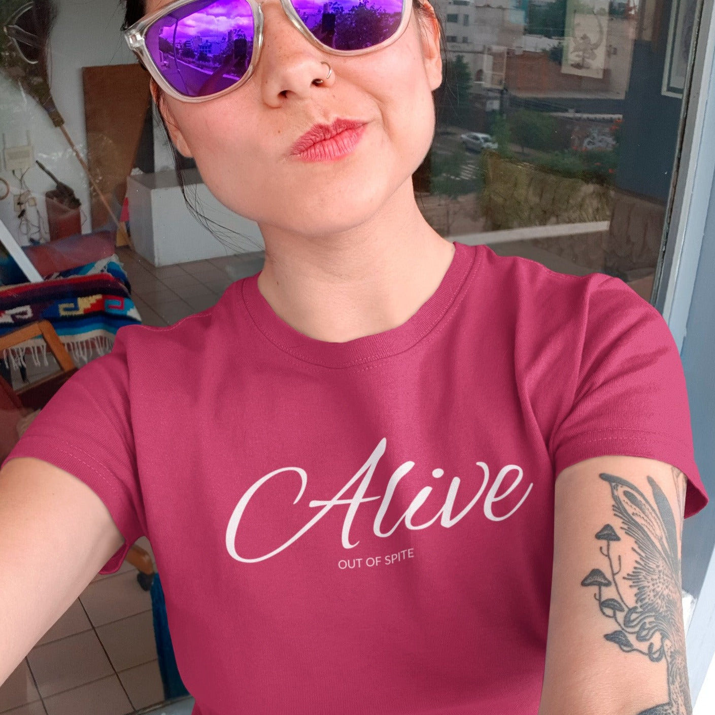 alive-out-of-spite-berry-t-shirt-funny-mockup-of-a-tattooed-woman-with-sunglasses-taking-a-selfie