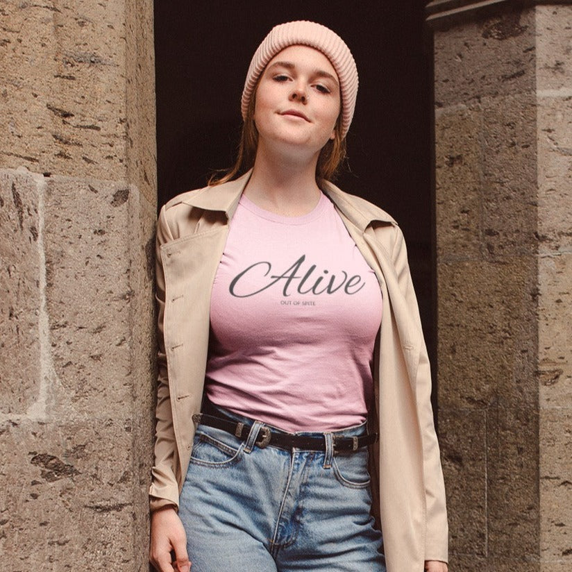alive-out-of-spite-pinkt-shirt-funny-mockup-featuring-a-woman-outside-a-stone-church