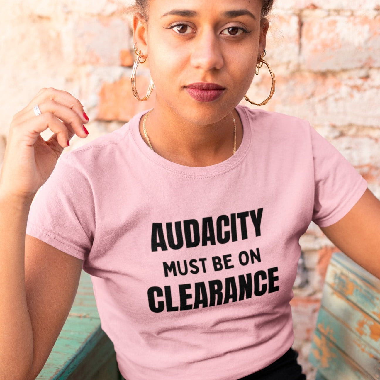 audacity-must-be-on-clearance-pink-t-shirt-unisex-funny-mockup-of-a-beautiful-girl-sitting-on-a-rustic-wooden-chair