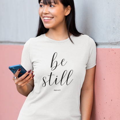 be-still-psalm-46-10-white-t-shirt-womens-christian-inspiring-tee-mockup-featuring-a-woman-leaning-against-a-pink-and-white-wall