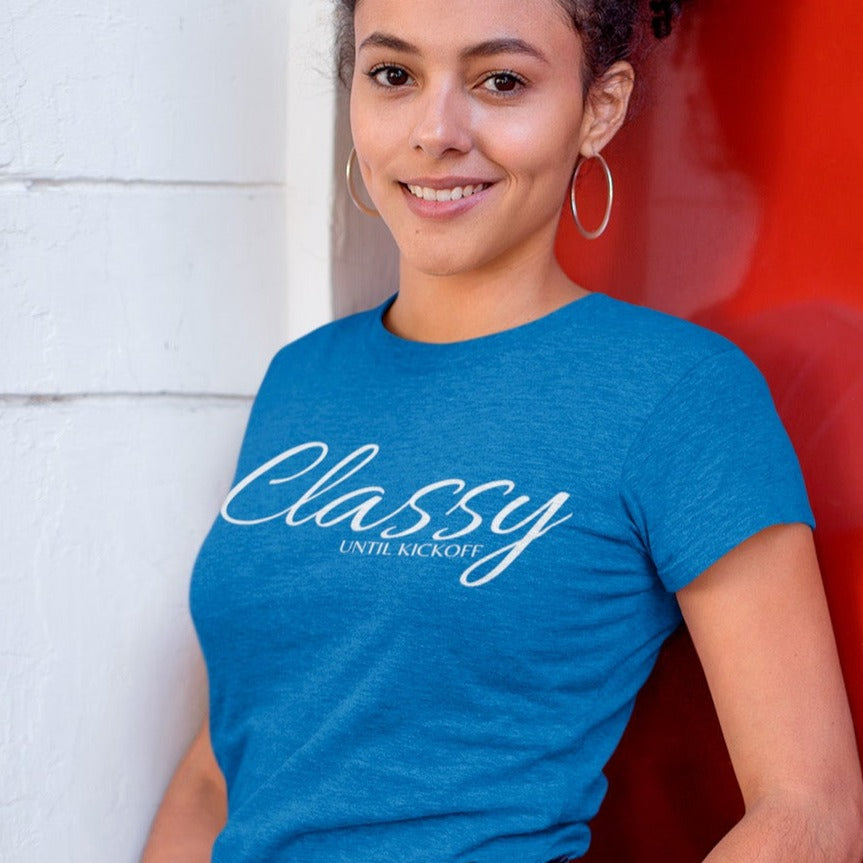 classy-until-kickoff-heather-true-royal-t-shirt-football-soccer-womens-mockup-of-a-kinky-haired-woman-leaning-on-a-red-metal-door