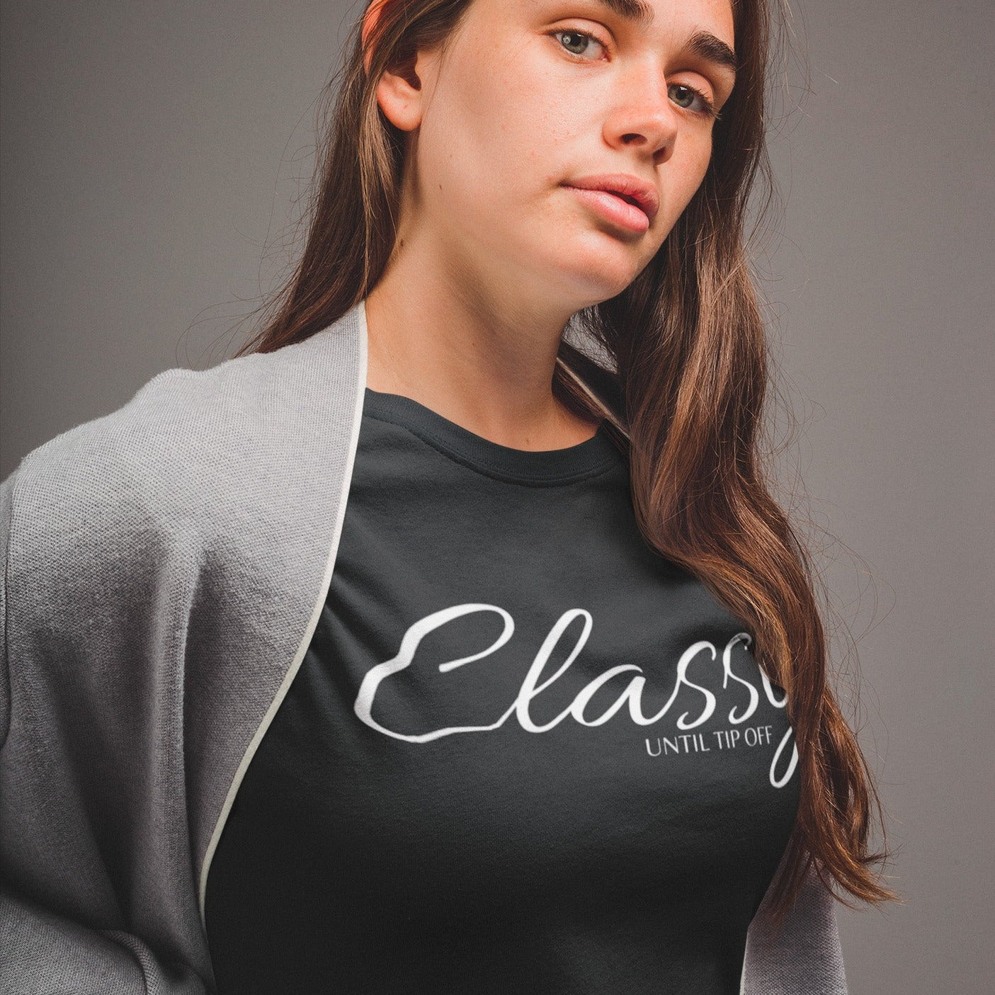 classy-until-tip-off-black-t-shirt-basketball-womens-partial-side-tee-mockup-of-a-pretty-woman-in-a-grey-room