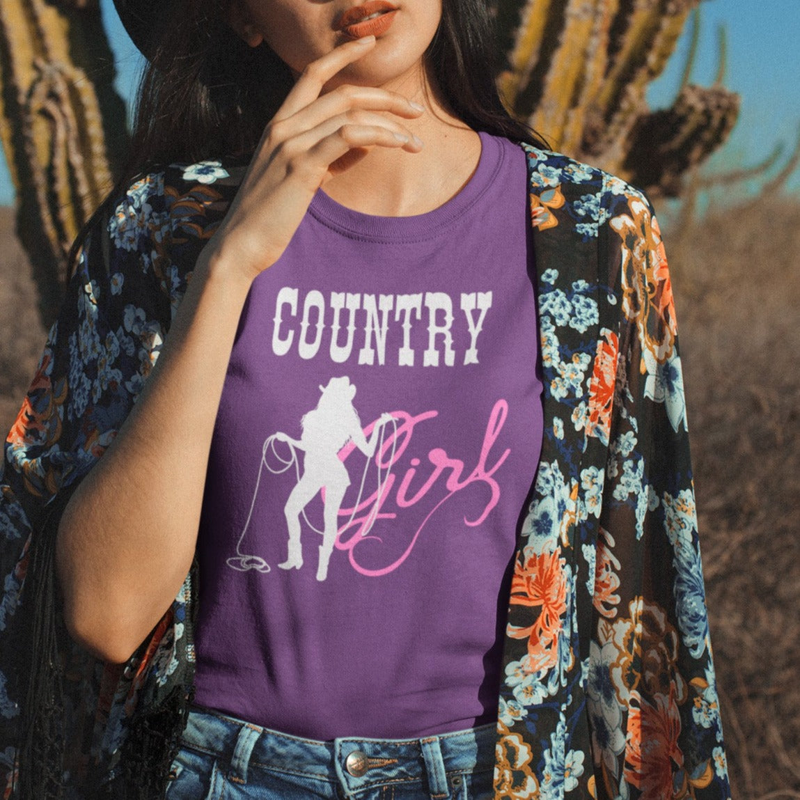country-girl-with-lasso-team-purple-t-shirt-cowgirl-tee-mockup-featuring-a-hipster-girl-posing-against-a-cactus