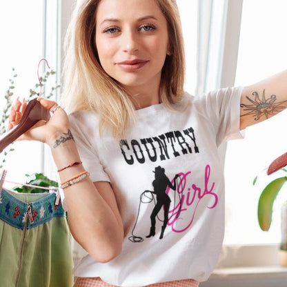 country-girl-with-lasso-white-t-shirt-cowgirl-mockup-of-a-woman-with-an-arm-tattoo-posing-by-a-clothing-rack