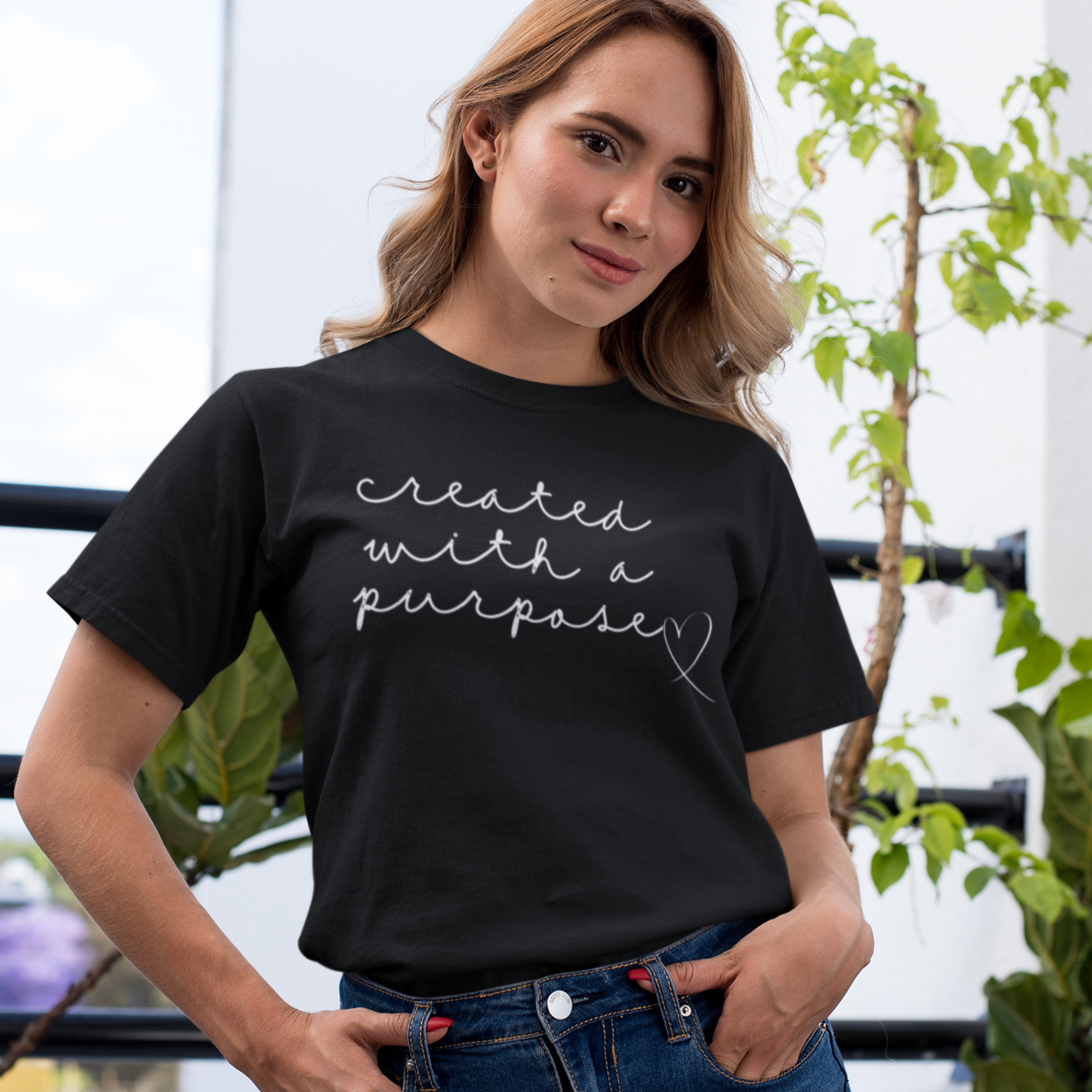 created-with-a-purpose-black-t-shirt-mockup-of-a-girl-with-a-coy-smile-by-a-balcony