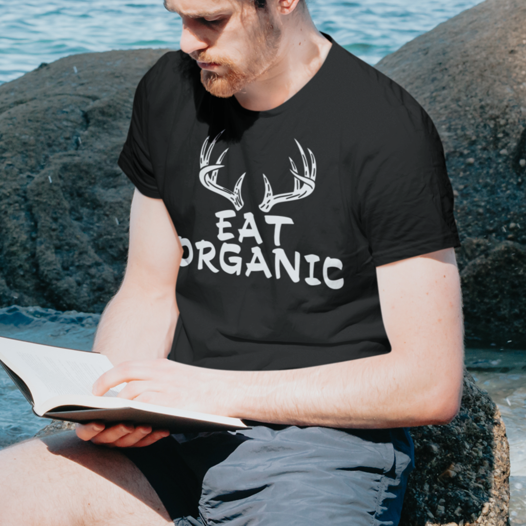 eat-organic-blackt-shirt-mockup-of-a-man-reading-a-bible-by-the-beach