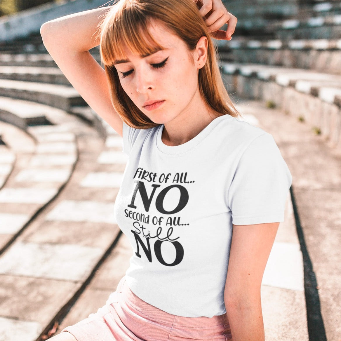 first-of-all-no-second-of-all-no-white-t-shirt-sarcastic-women-mockup-of-a-pretty-girl-wearing-a-tee-and-posing-in-an-empty-stadium