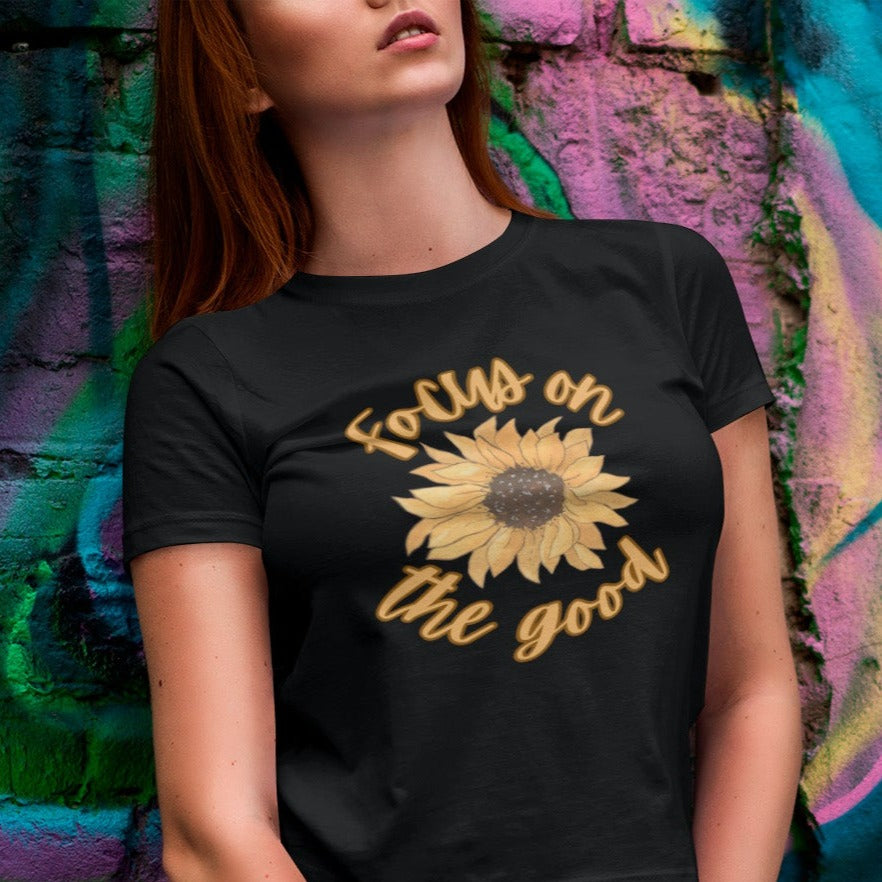 focus-on-the-good-sunflower-black-t-shirt-womens-mockup-of-a-woman-in-a-tee-leaning-on-a-wall-with-graffiti