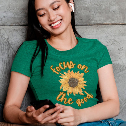 focus-on-the-good-sunflower-heather-kelly-green-t-shirt-womens-mockup-of-a-woman-sitting-on-the-stairs