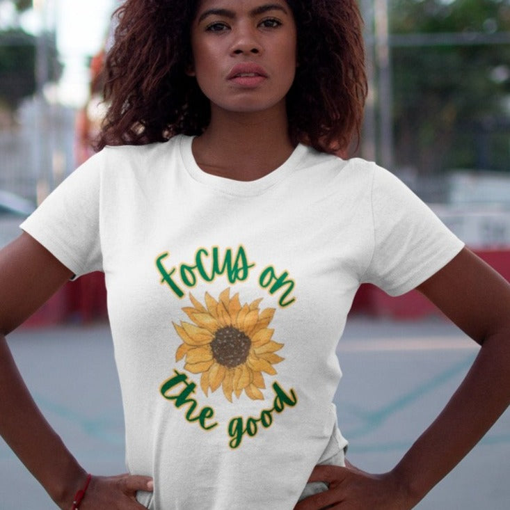focus-on-the-good-sunflower-white-t-shirt-womens-young-woman-with-her-hands-on-her-waist-standing-outdoors-while-wearing-a-tee