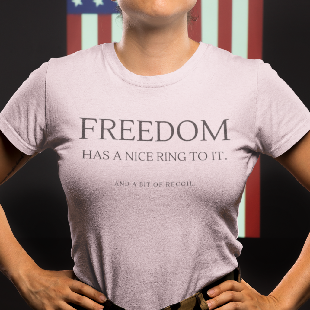 freedom-has-a-nice-ring-to-it-and-a-bit-of-recoil-pink-t-shirt-2a-mockup-of-a-woman-veteran-standing-against-an-american-flag