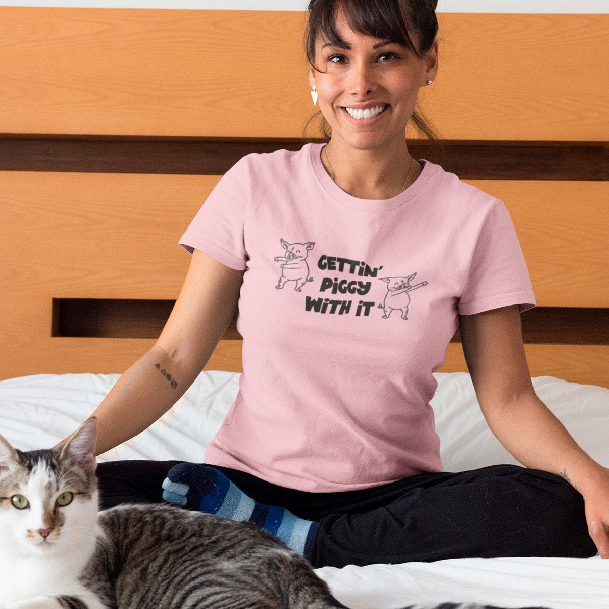 gettin-piggy-with-it-pink-t-shirt-funny-dancing-pigs-portrait-of-a-happy-cat-owner-wearing-a-t-shirt-mockup-on-bed