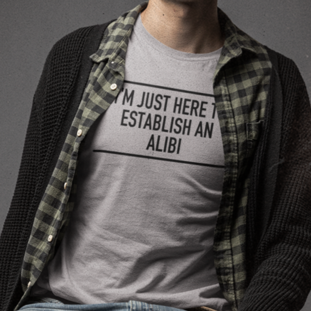 im-just-here-to-establish-an-alibi-athletic-heather-t-shirt-bella-canvas-t-shirt-mockup-featuring-a-serious-man-sitting-on-a-stool