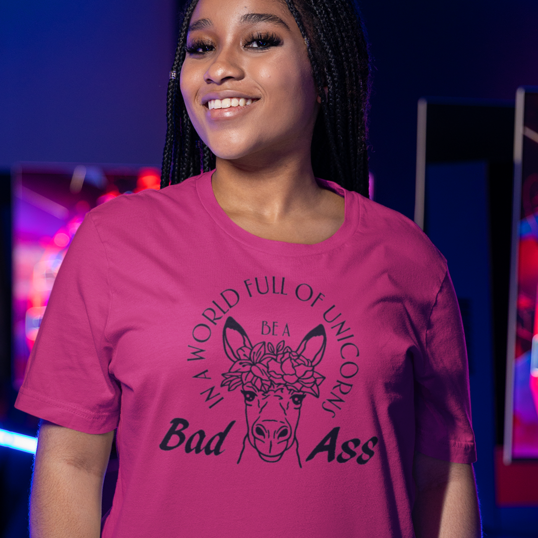 in-a-world-full-of-unicorns-be-a-bad-ass-berry-t-shirt-womens-funny-donkey-mockup-of-a-woman-posing-at-a-gamers-arena