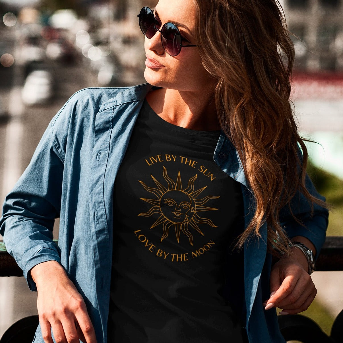 live-by-the-sun-love-by-the-moon-black-t-shirt-with-sun-and-moon-design-mockup-of-a-woman-with-long-hair-wearing-a-crewneck-tee-outside